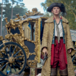 Nell'immagine Nell, con alle spalle una carrozza, la protagonista della serie disney Nell rinnegata